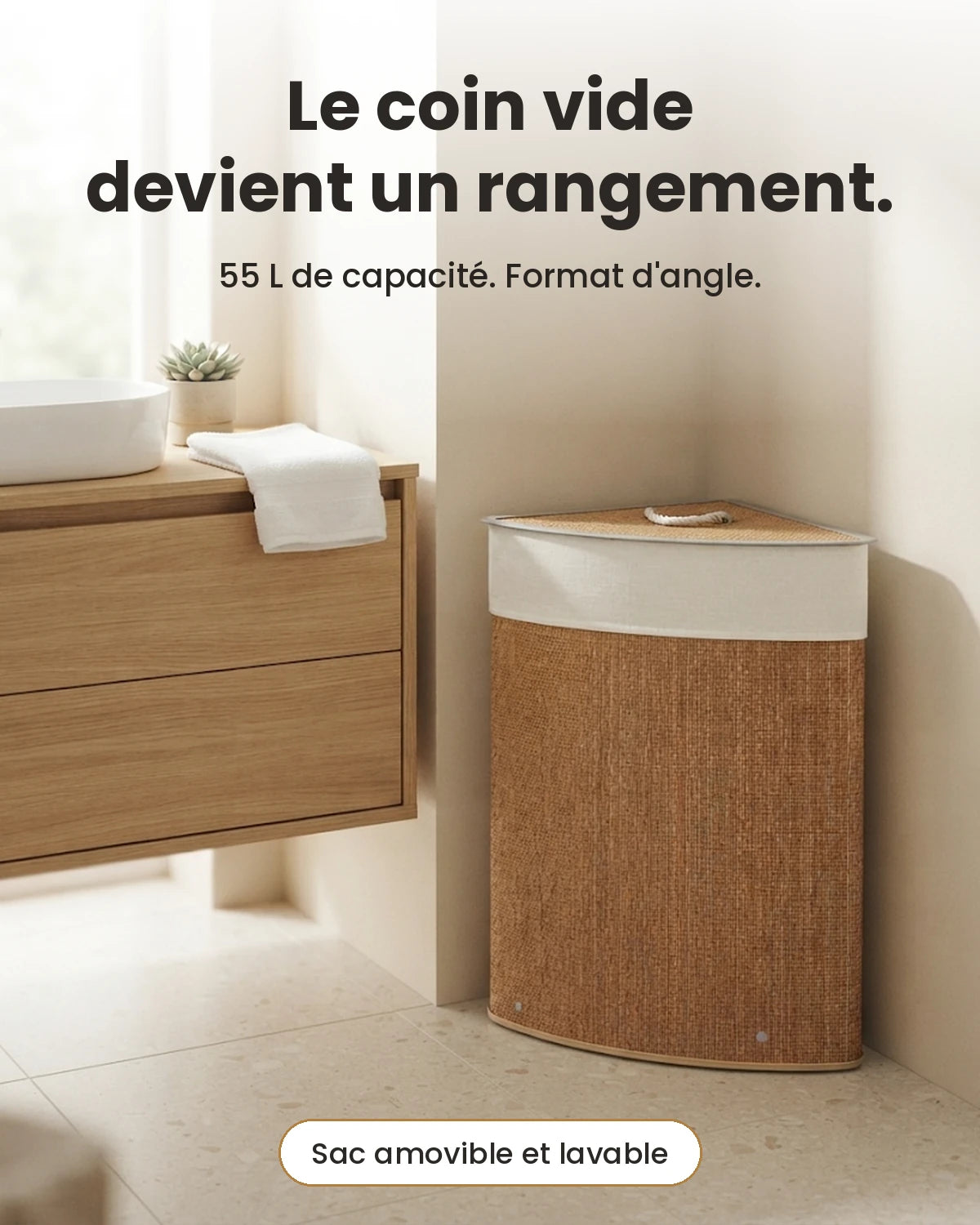 Panier à linge d'angle en bambou marron 55 L dans le coin d'une salle de bain, à côté d'un meuble vasque en bois