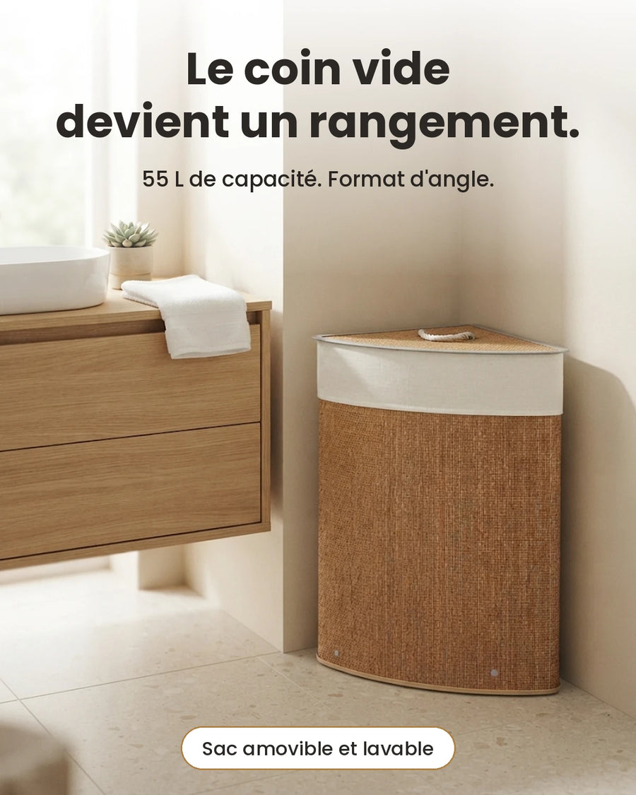 Panier à linge d'angle en bambou marron 55 L dans le coin d'une salle de bain, à côté d'un meuble vasque en bois