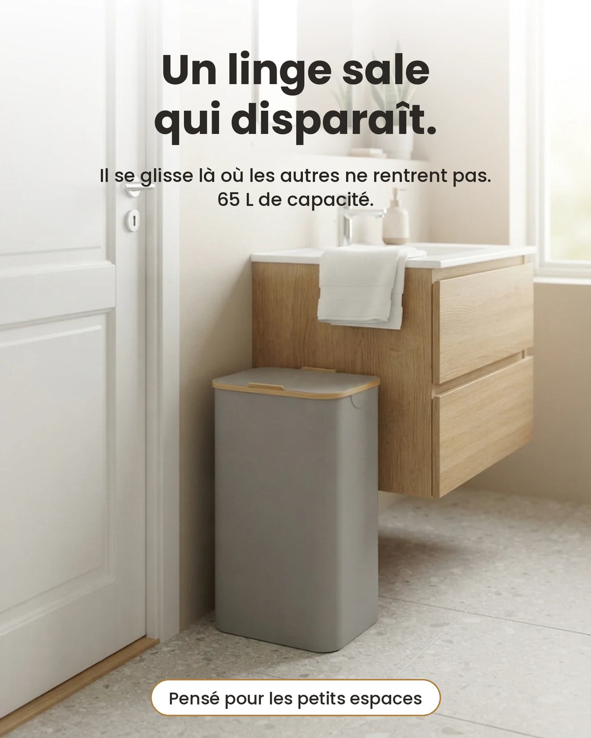 Panier à linge étroit 65 L gris clair avec couvercle bambou, glissé entre une porte et un meuble de salle de bain